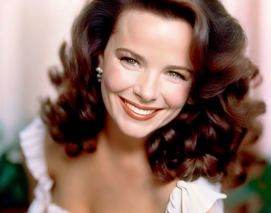 Brunette woman in off-shoulder top with bright smile and earrings