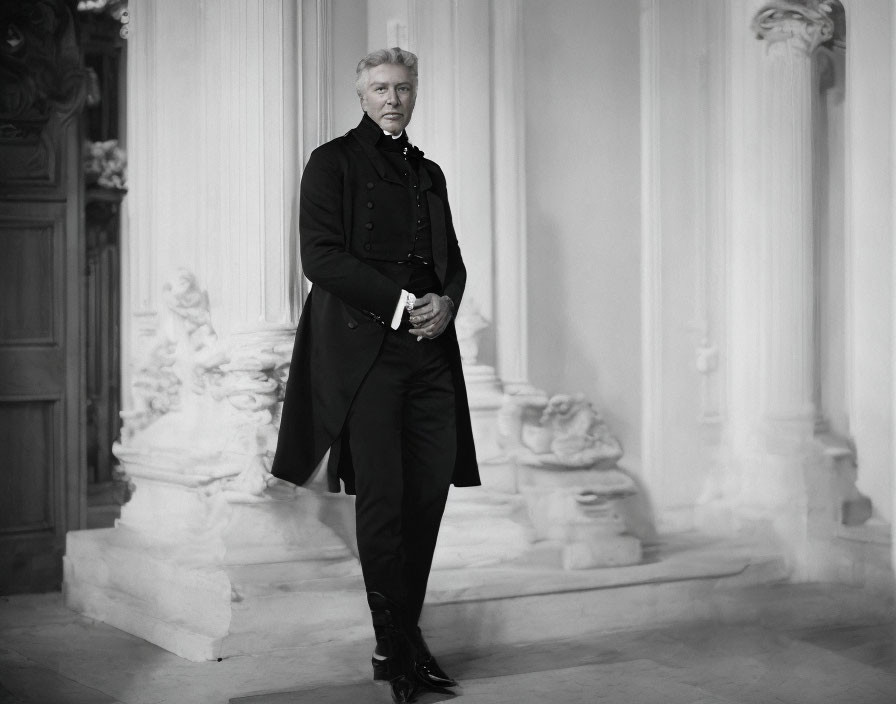 Monochrome photo of distinguished man in dark coat in classical interior