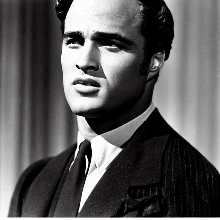 Monochrome image of man in pinstripe suit with classic hairstyle