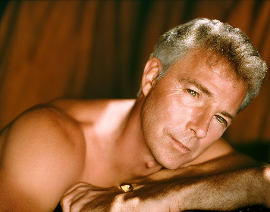 Mature man with salt-and-pepper hair gazes at camera