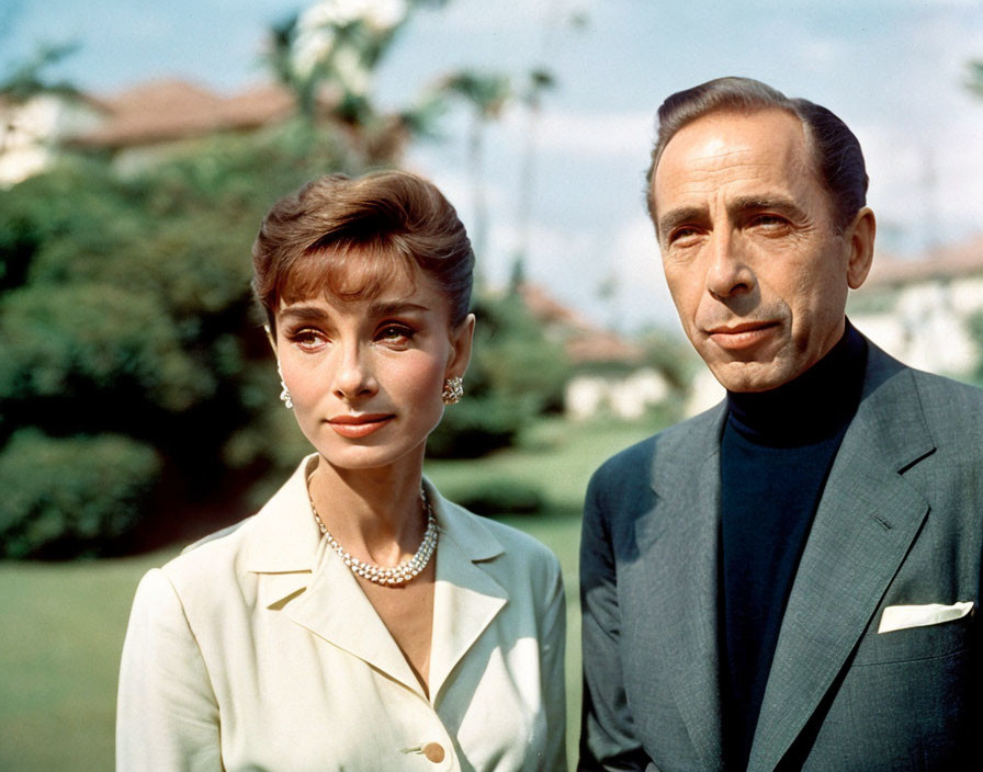 Contemplative man and woman in suits with greenery background