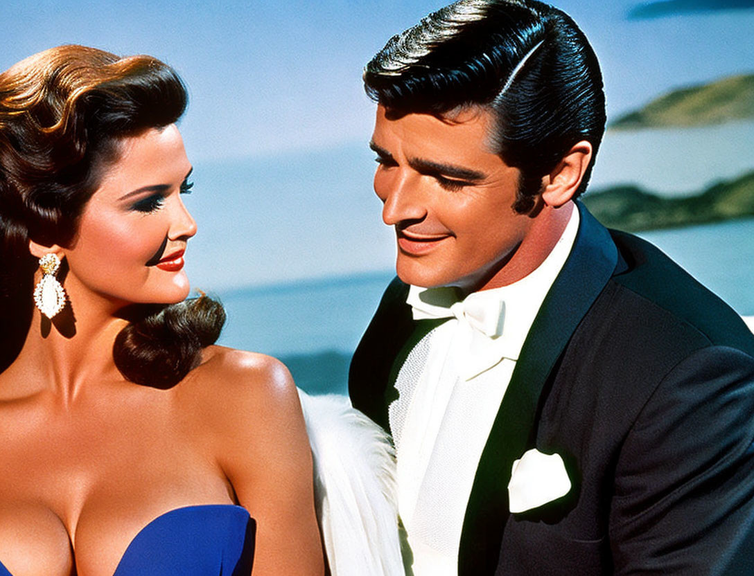 Man in tuxedo admiring woman with wavy hair in tropical setting