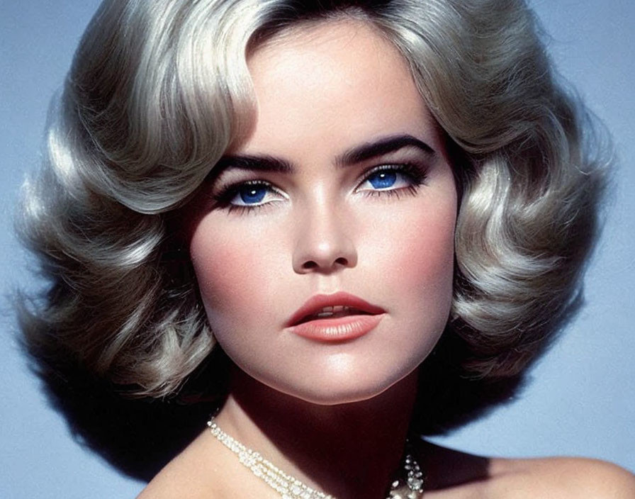 Voluminous wavy hair, blue eyes, pearl necklace: Classic beauty with a vintage touch