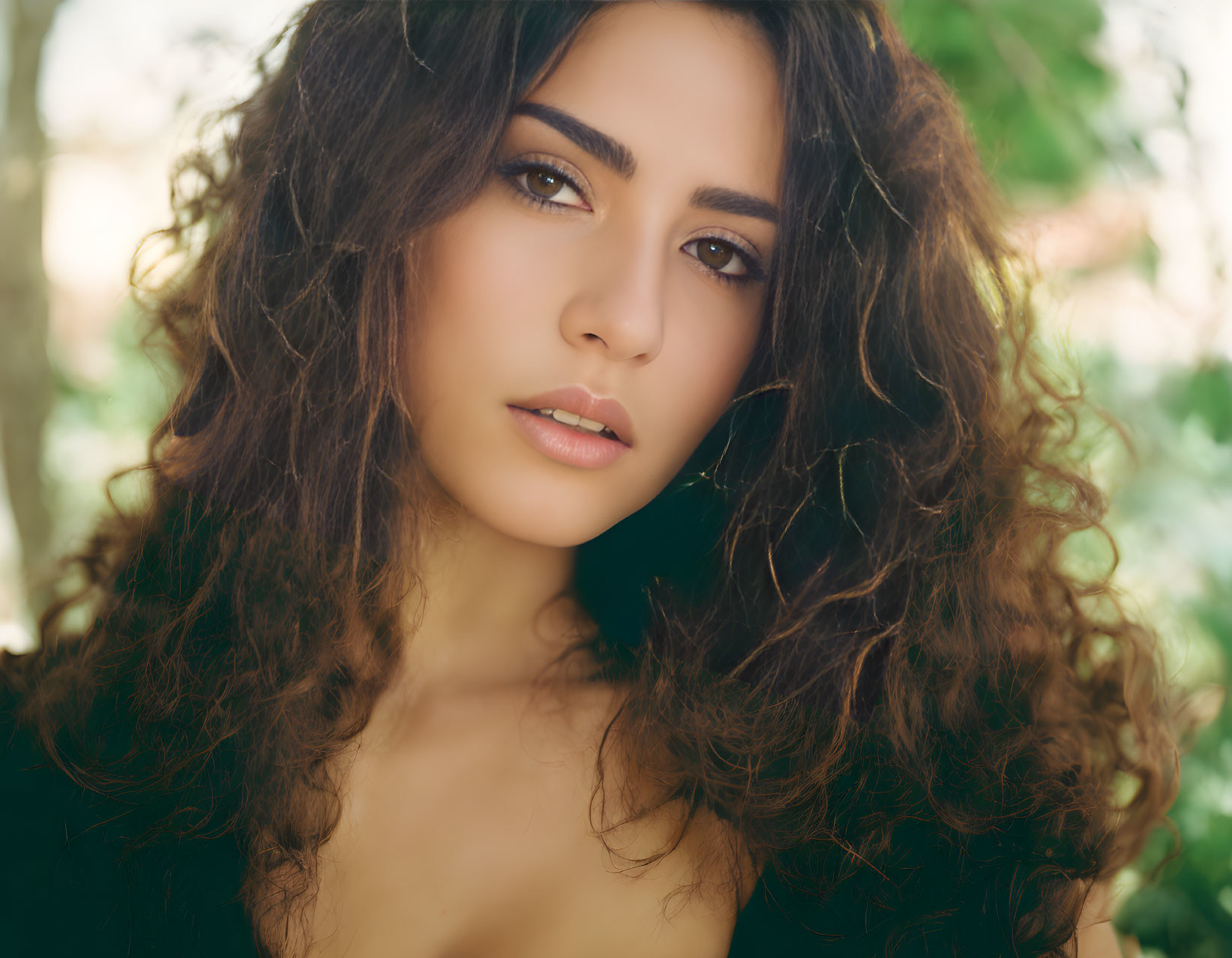 Portrait of Woman with Voluminous Curly Hair and Intense Gaze