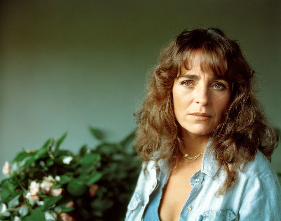 Woman with Curly Hair in Denim Shirt and Necklace Posing Outdoors