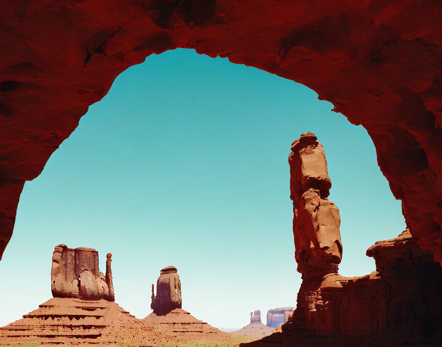 Natural arch frames towering rock formations in desert landscape