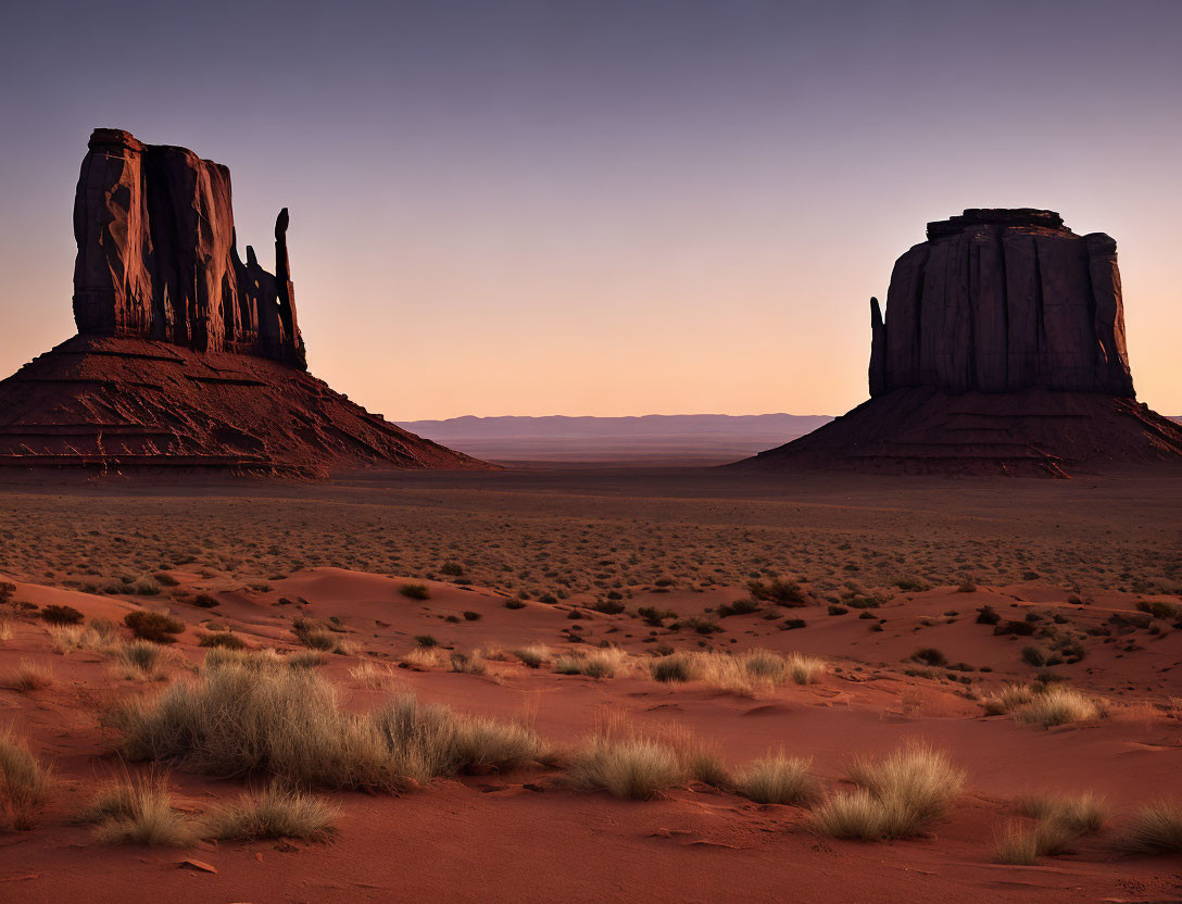 Iconic red sandstone buttes in Monument Valley at sunrise.