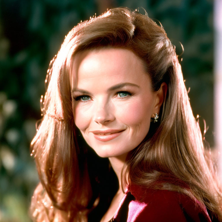 Smiling woman with auburn hair in red outfit and earrings