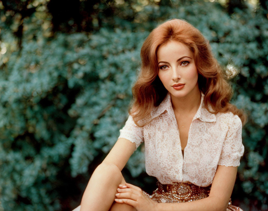 Auburn-Haired Woman in Lace Top and Belted Skirt Sitting by Shrubbery