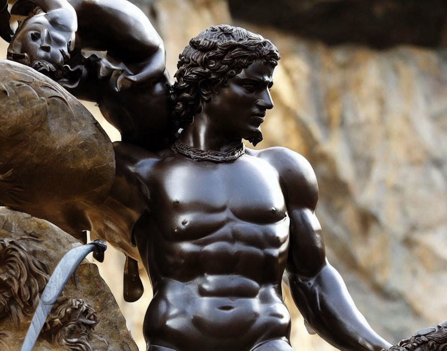 Muscular male bronze statue holding stone, detailed musculature, necklace, blurred background