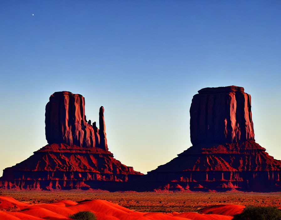 Red Sandstone Buttes in Monument Valley at Dusk with Crescent Moon