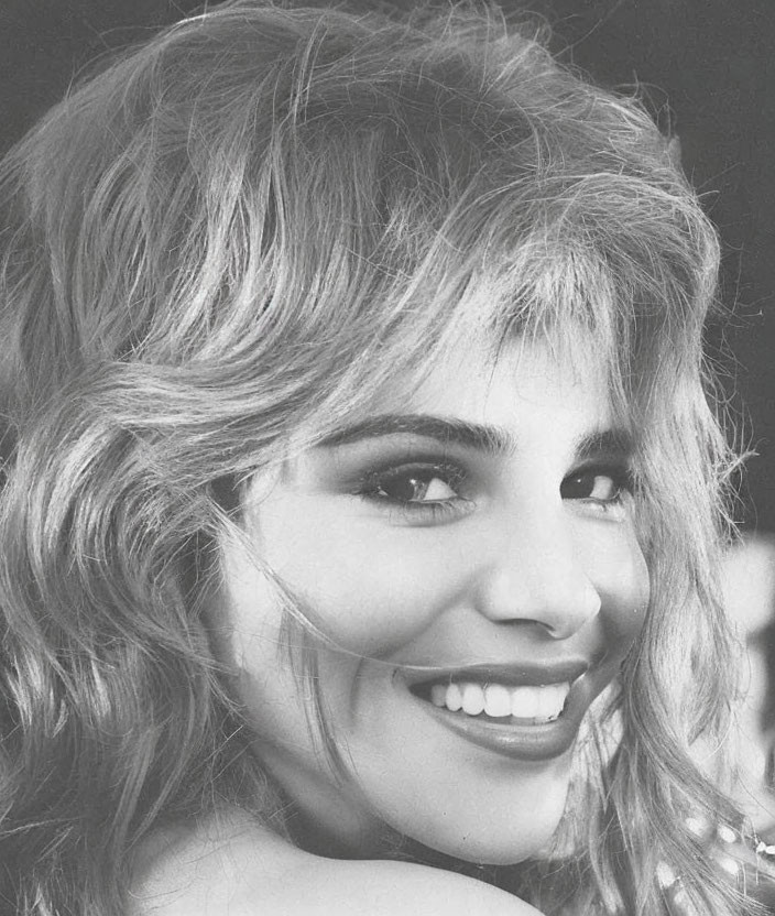 Smiling woman with voluminous hair in black and white portrait