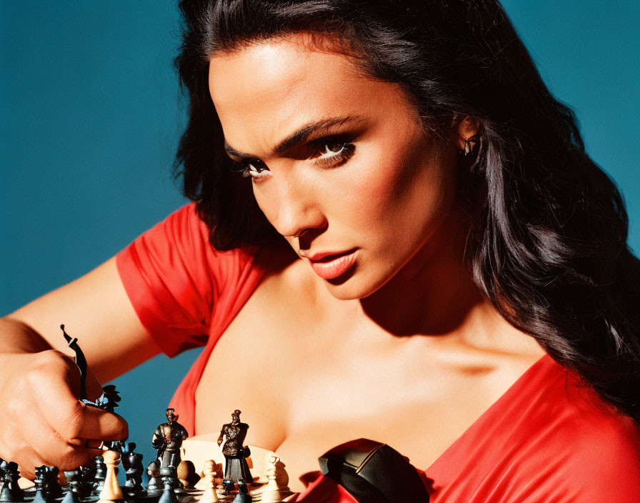 Woman in red outfit concentrating on chessboard against blue backdrop