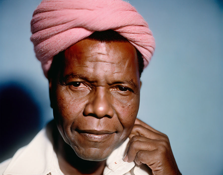 Portrait of a man in pink turban and white shirt with thoughtful expression