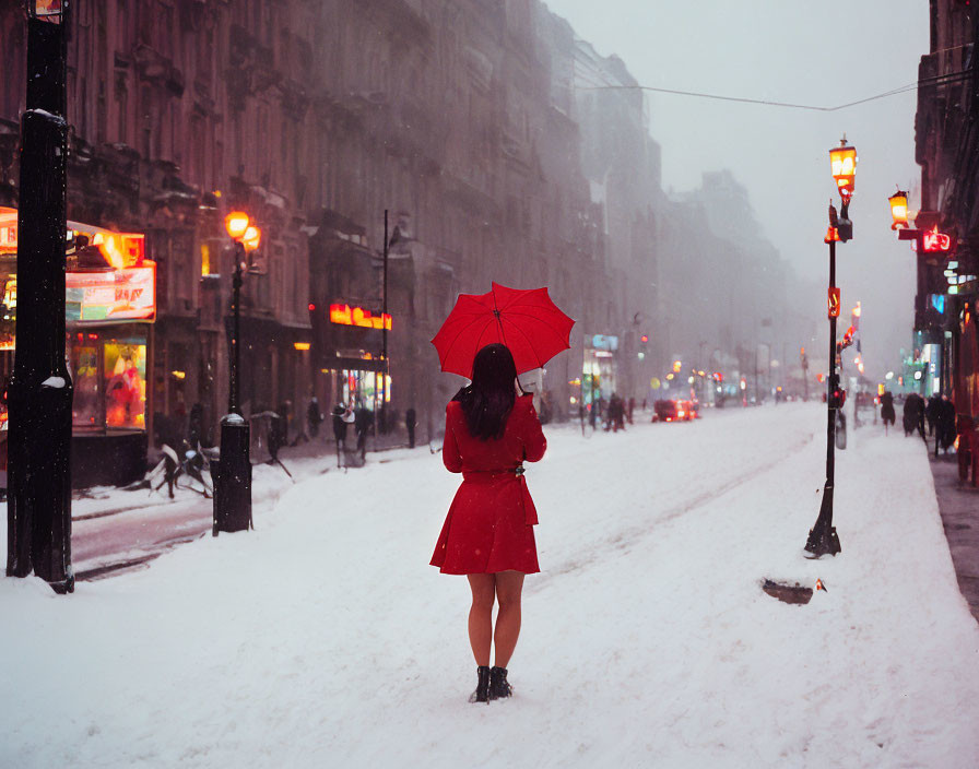 Person in Red Coat with Red Umbrella on Snowy Street with Vintage Lampposts and Shop