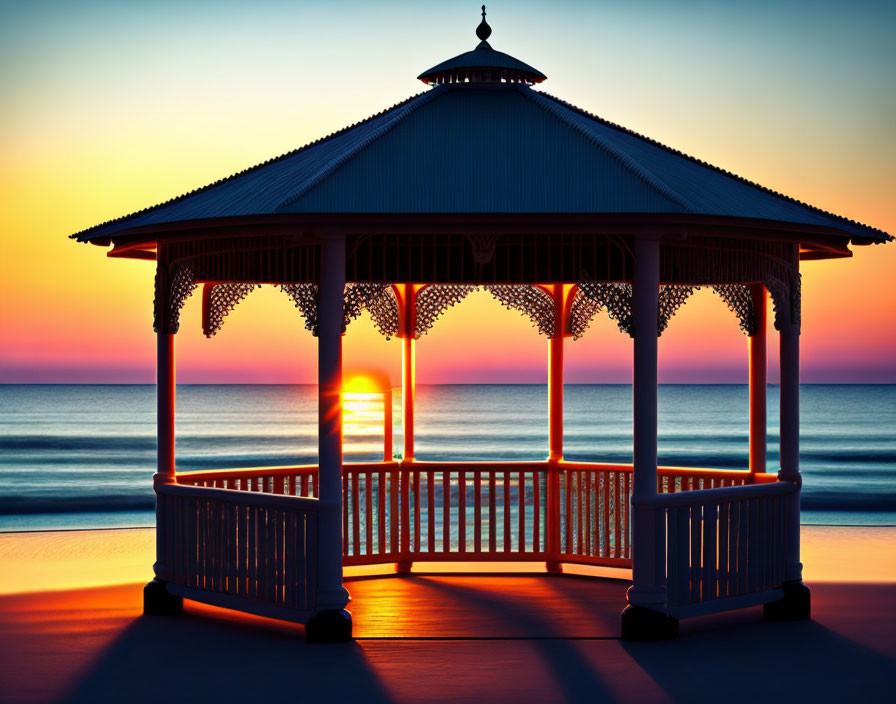 Ornate gazebo silhouette at sunset by the ocean