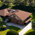 Luxurious house with brown tiled roof in lush tropical setting and yellow car in driveway