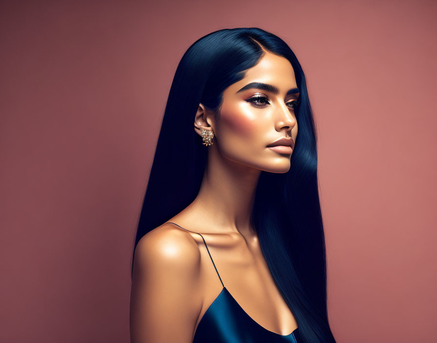 Dark-haired woman in elegant pose on pink background with sleek dress and sparkly earring