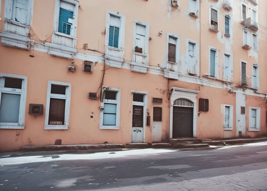 Faded orange building with closed shutters on deserted street