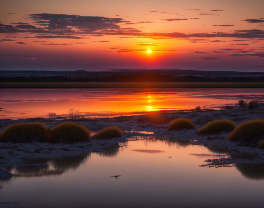 Tranquil sunset with vibrant oranges and purples reflected in calm waters