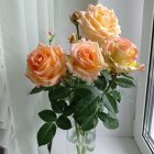 Hyper-realistic painting of peach roses and blue/purple flowers in glass vase on table with white curtains