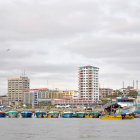 Colorful Coastal Town with Modern Tower & Boats in Blue Sky