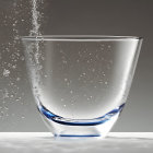 Transparent glass with water and bubbles on grey background