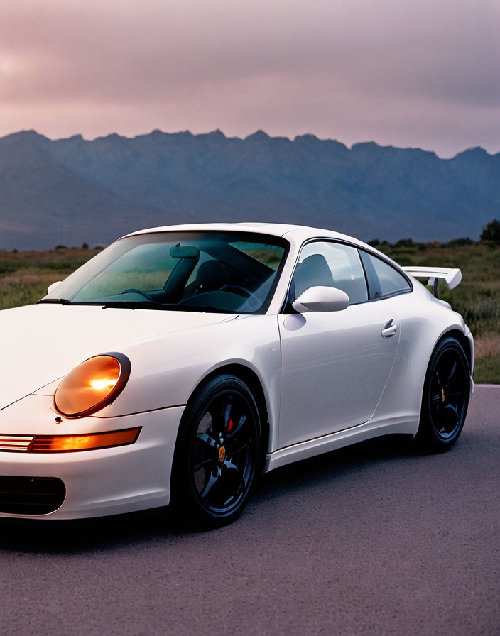 White Porsche 911 with Black Rims Parked on Road at Dusk