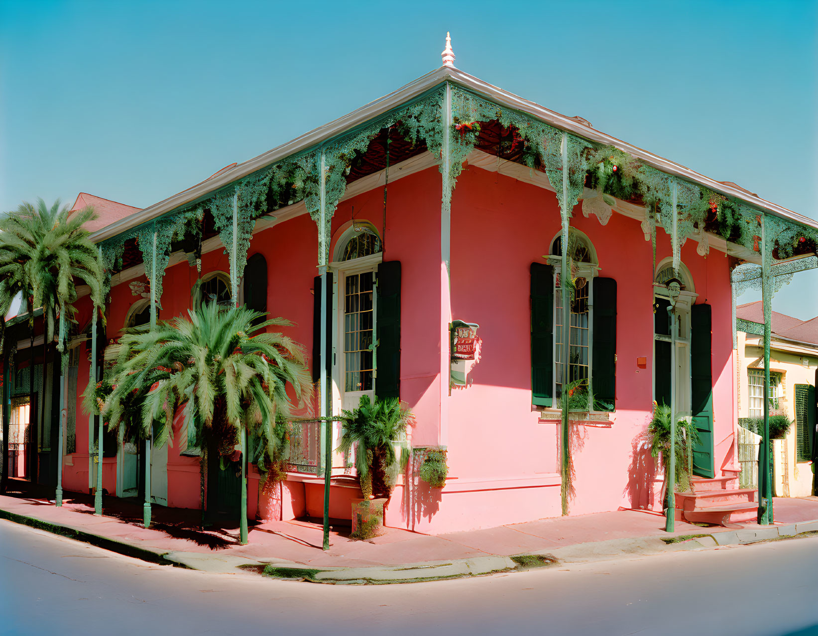 Vibrant Pink Traditional House with Green Shutters and Ferns