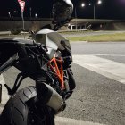 Futuristic glowing motorcycle parked on city street at night