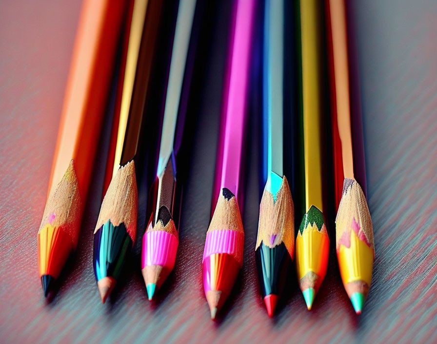 Vibrant colored pencils in a row on textured surface