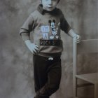 Monochrome image of young child in coat on textured blanket