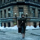 Vintage street scene with classic attire, carriages, and old tram from early 20th century