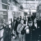 Group of soldiers in gear marching through dimly lit industrial corridor