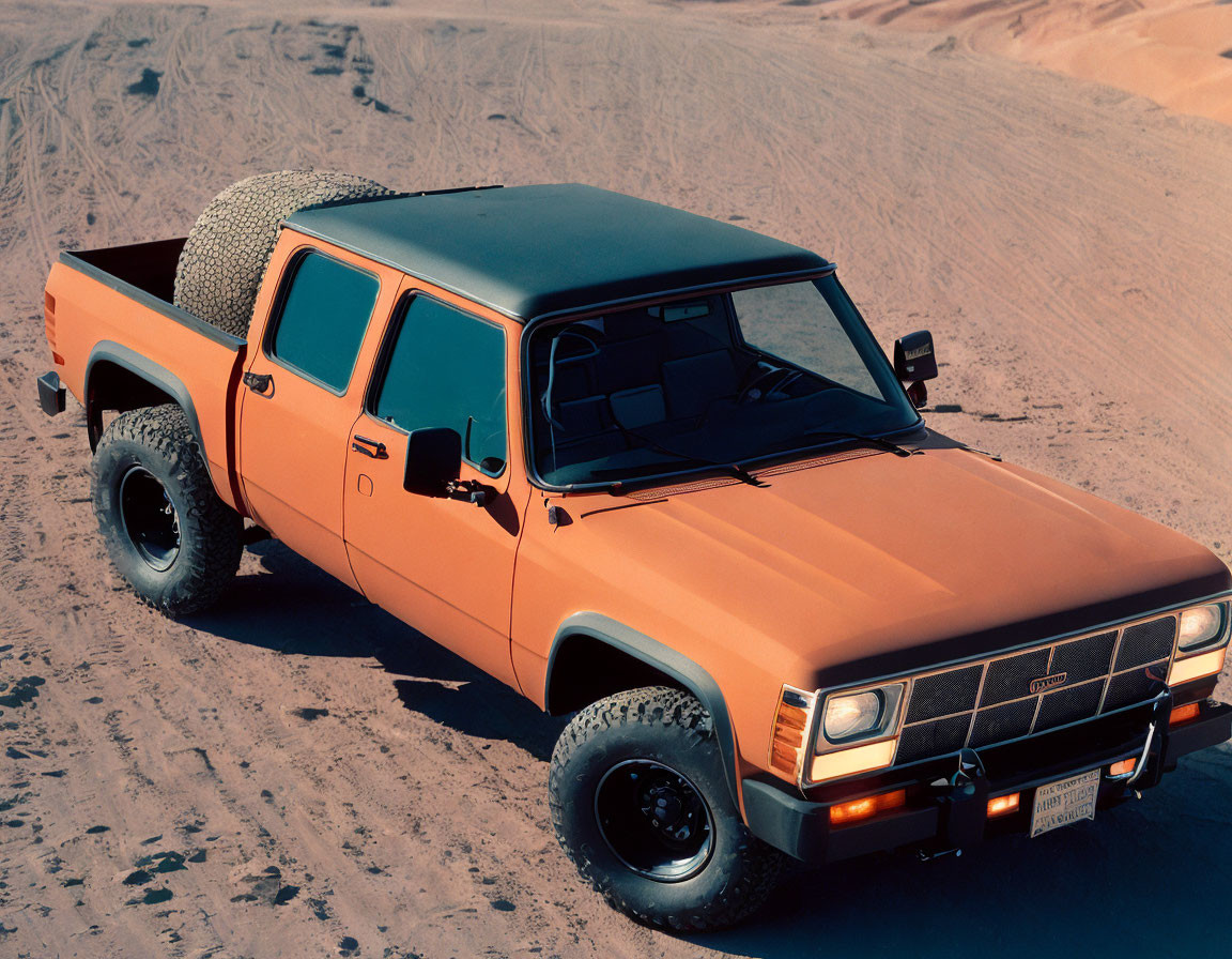 Vintage Orange Pickup Truck with Spare Tire Parked on Sandy Desert Terrain