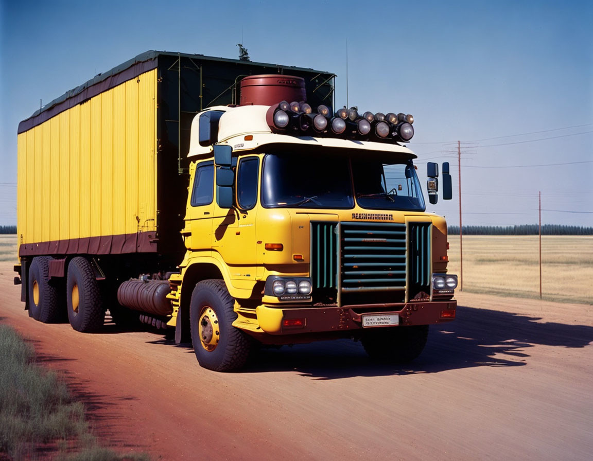 Yellow Semi-Truck with Large Trailer and Chrome Accents on Road