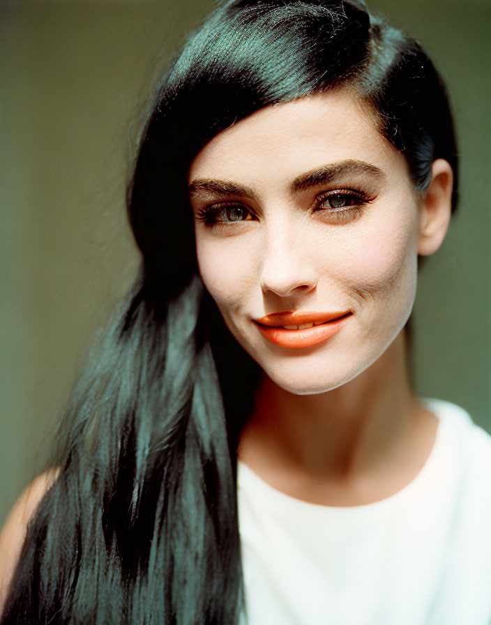 Portrait of woman with dark hair and bright lipstick smiling gently