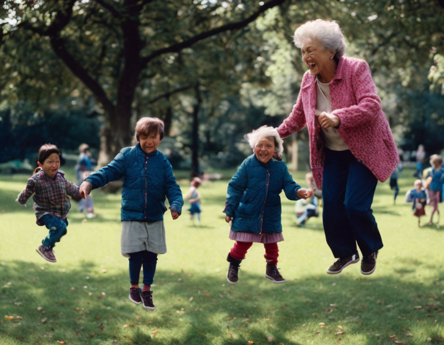 Elderly woman and three children jumping in sunny park