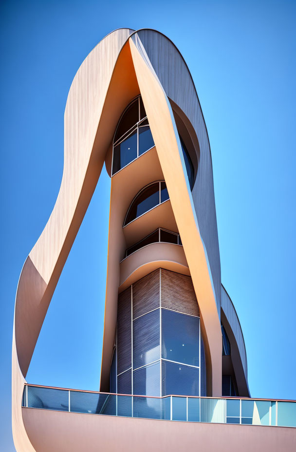 Contemporary curved architectural building with glass windows under clear blue sky