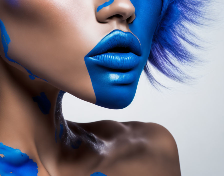 Person with Vibrant Blue Lipstick and Matching Blue Paint on Skin and Feathers