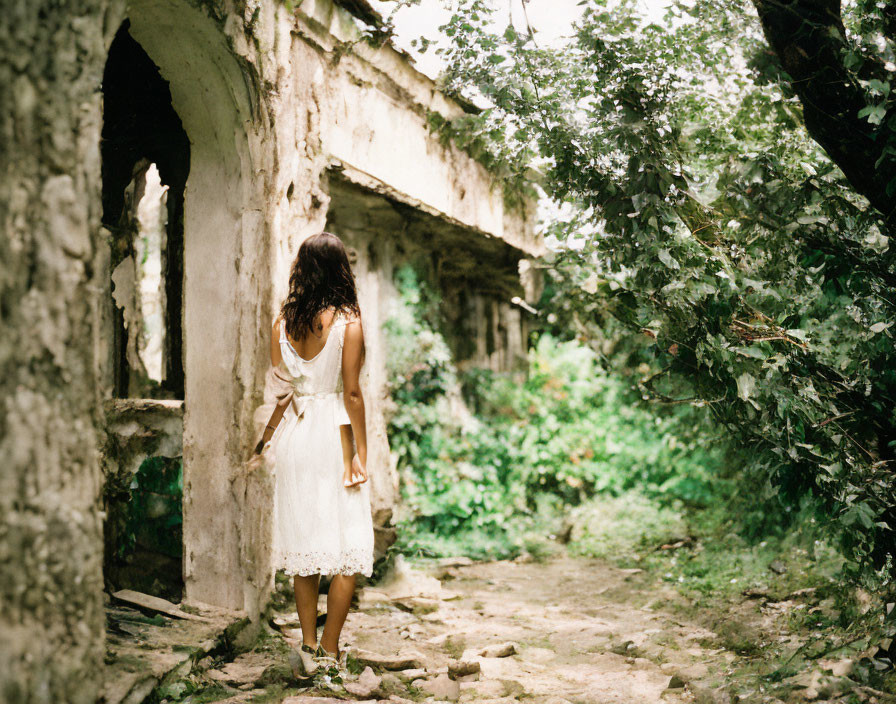 Woman in White Dress Amidst Overgrown Ruins