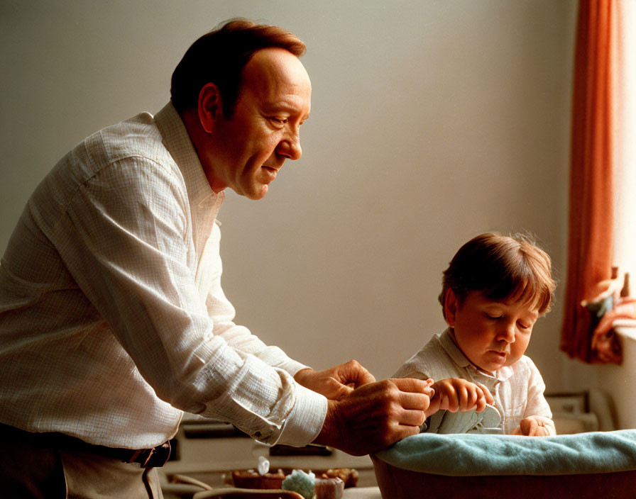 Adult smiling at child with birthday cake and candle in warmly lit room