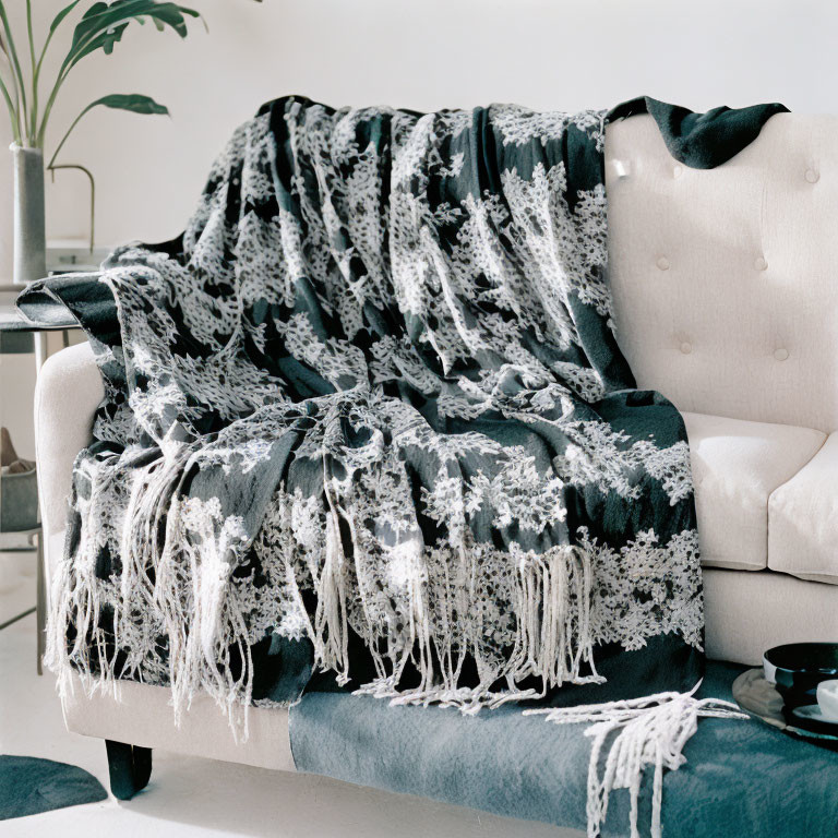 Cozy room with white and black throw blanket on beige armchair