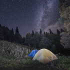 Luminous planet in cosmic landscape with starry sky and nebula