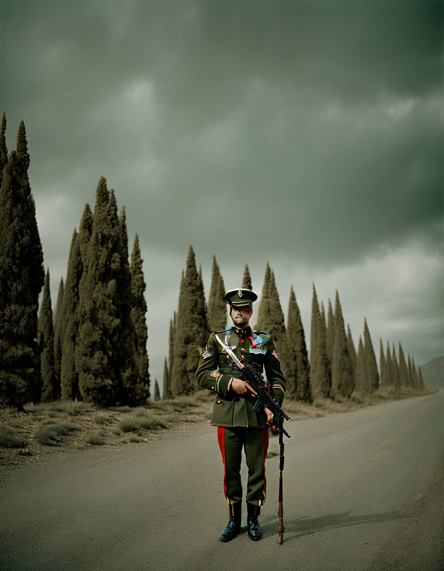 Person in uniform with rifle on deserted road among cypress trees under cloudy sky