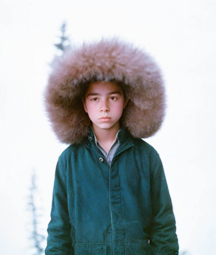 Person in Fluffy Fur Hat and Dark Coat in Snowy Landscape