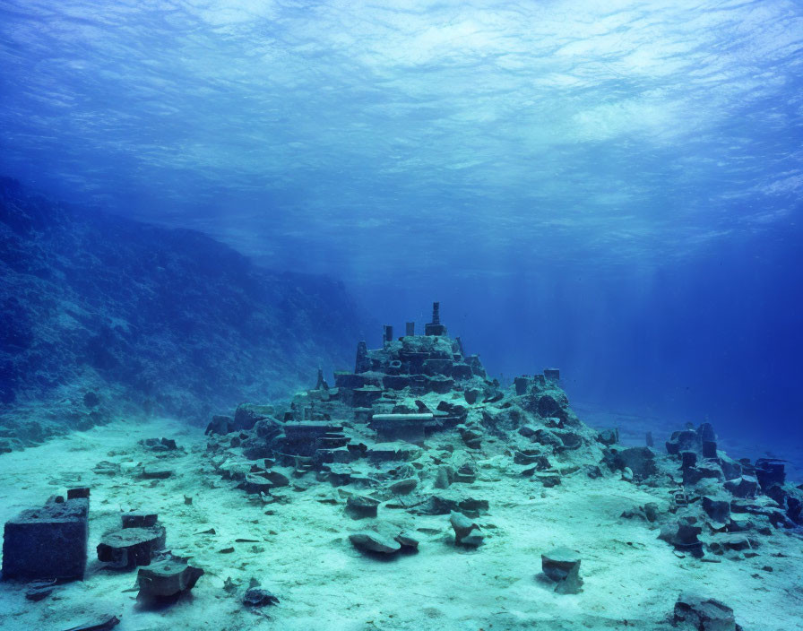 Ancient ruins on ocean floor surrounded by blue aquatic landscape