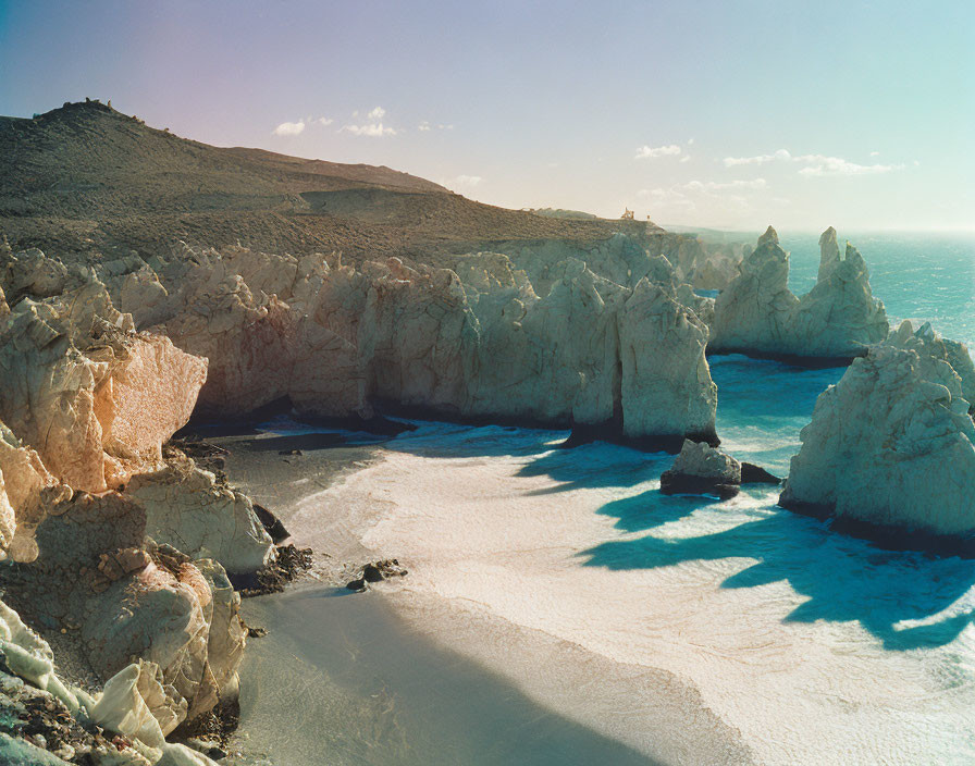 Rugged white cliffs and rock formations on serene blue coastline