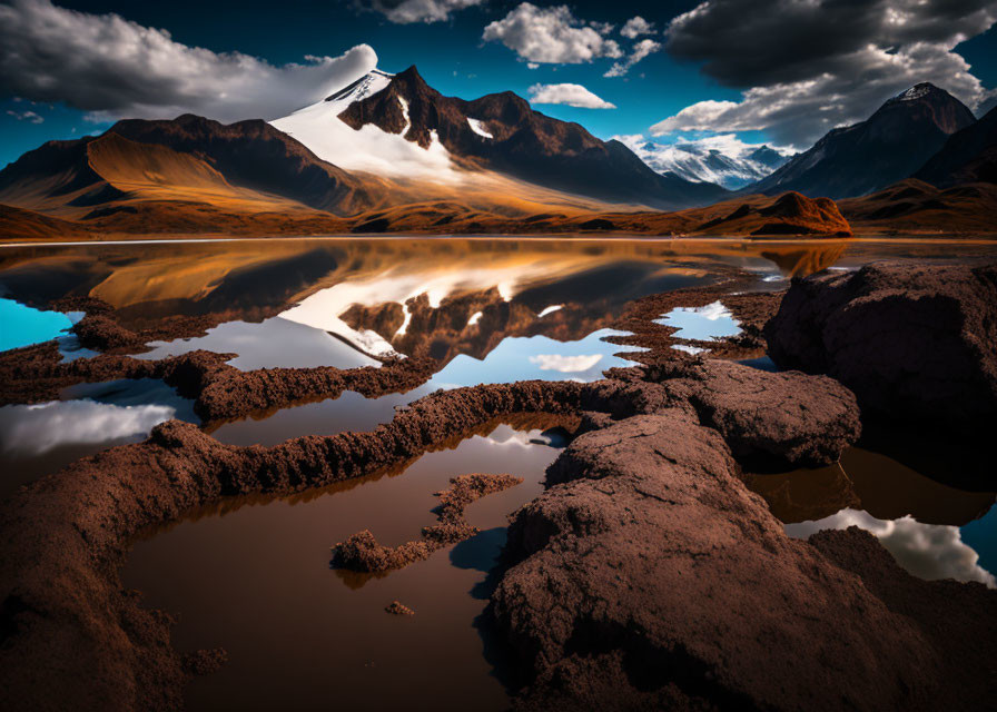 Rugged mountains under blue sky reflected in serene water landscape