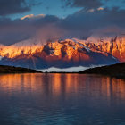 Tranquil lake reflecting majestic mountain range at sunset